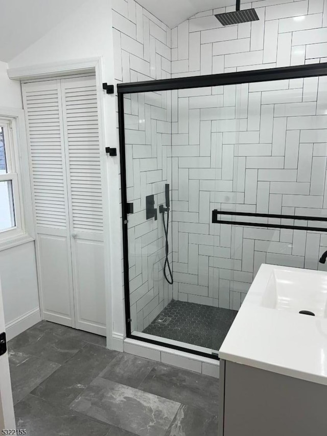 bathroom with marble finish floor, a closet, a shower stall, vanity, and baseboards