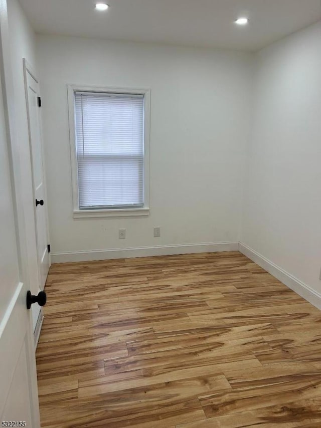 spare room with light wood-type flooring, baseboards, and recessed lighting