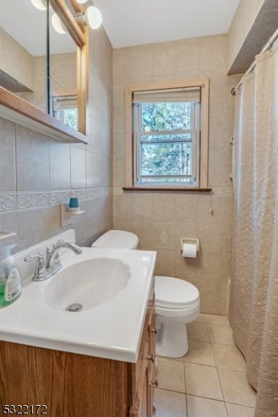 bathroom with tile patterned floors, toilet, a shower with curtain, tile walls, and vanity