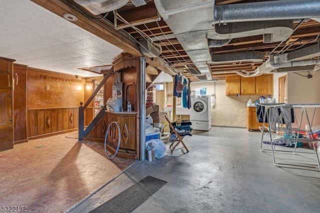 basement with washer / clothes dryer and wooden walls