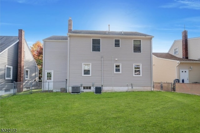 rear view of property with a lawn and central AC unit