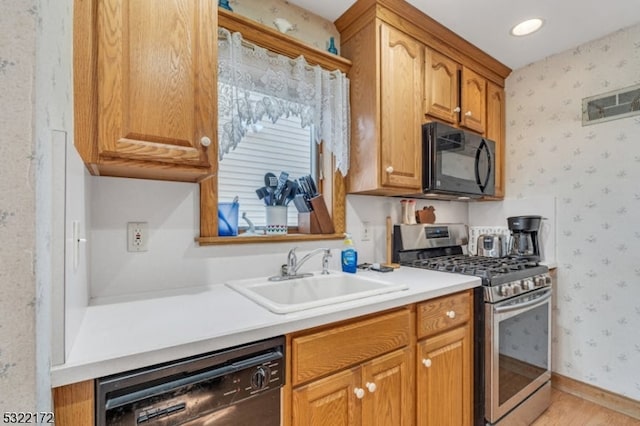 kitchen with light hardwood / wood-style floors, black appliances, and sink