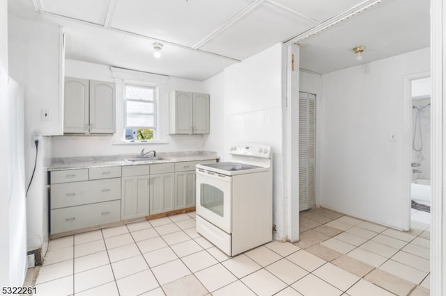 kitchen featuring gray cabinets, sink, light tile patterned floors, and white range with electric cooktop