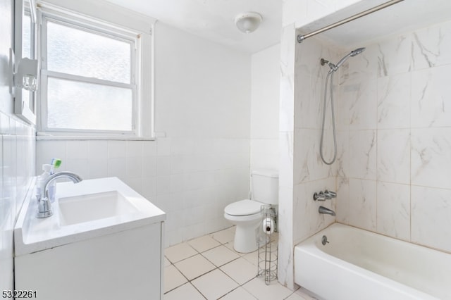 full bathroom featuring tiled shower / bath, tile walls, toilet, vanity, and tile patterned flooring