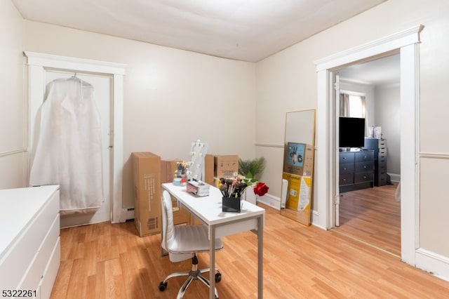 office featuring light hardwood / wood-style floors and a baseboard heating unit