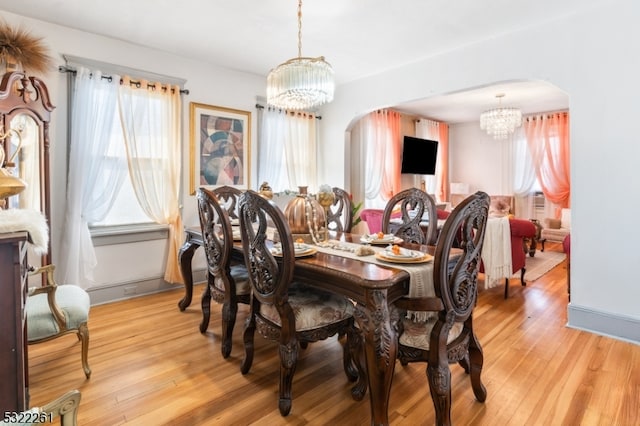 dining space featuring light hardwood / wood-style flooring and an inviting chandelier