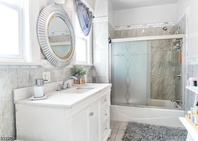 bathroom featuring vanity, enclosed tub / shower combo, tile patterned floors, and tile walls