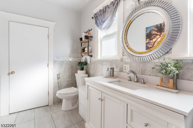 bathroom with vanity, toilet, tile patterned floors, and tile walls