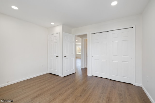 unfurnished bedroom with hardwood / wood-style flooring and a closet