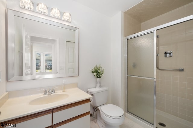 bathroom featuring vanity, toilet, and a shower with shower door