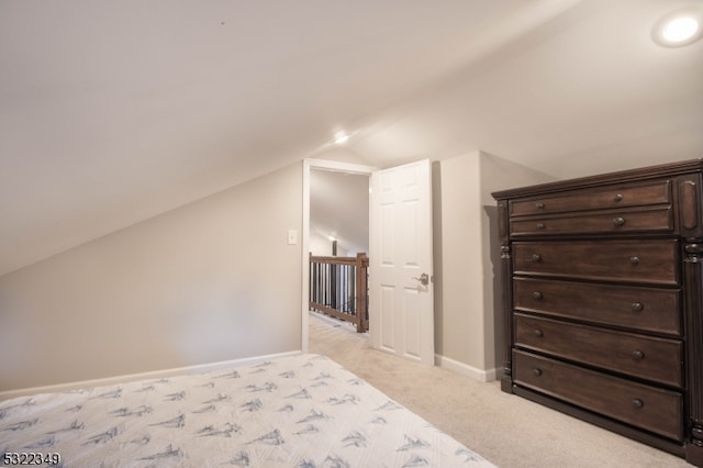 unfurnished bedroom featuring light carpet and vaulted ceiling