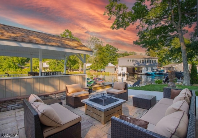 patio terrace at dusk featuring a gazebo and an outdoor living space with a fire pit