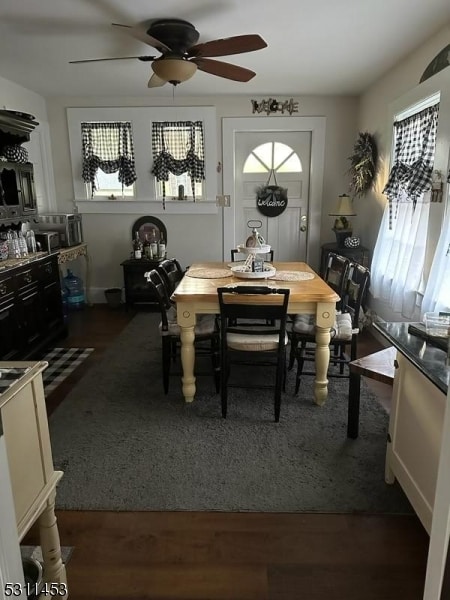 dining space with dark hardwood / wood-style floors and ceiling fan