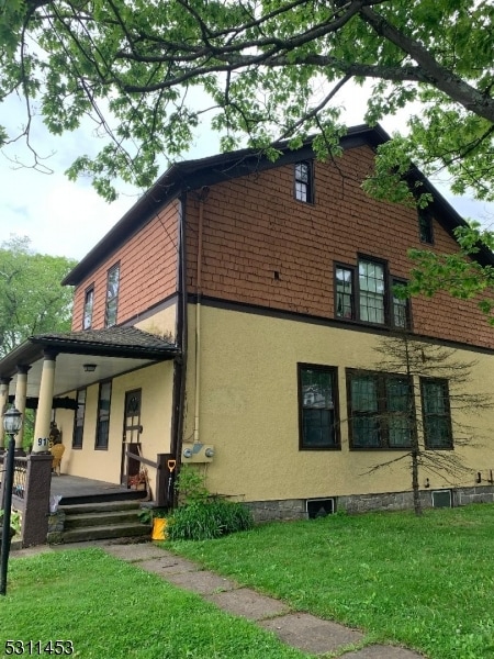 view of property exterior featuring a porch and a yard