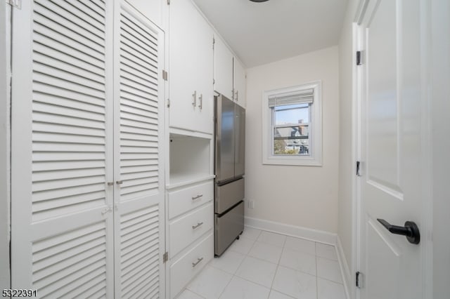 kitchen featuring stainless steel fridge and white cabinets