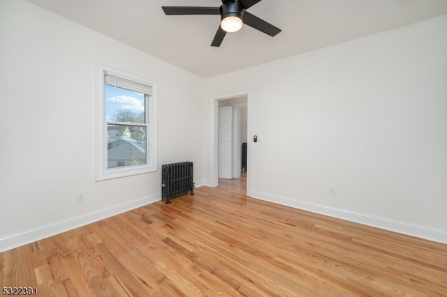 empty room with light wood-type flooring, radiator heating unit, and ceiling fan