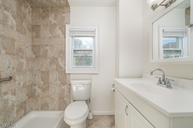 bathroom featuring plenty of natural light, vanity, toilet, and a tile shower