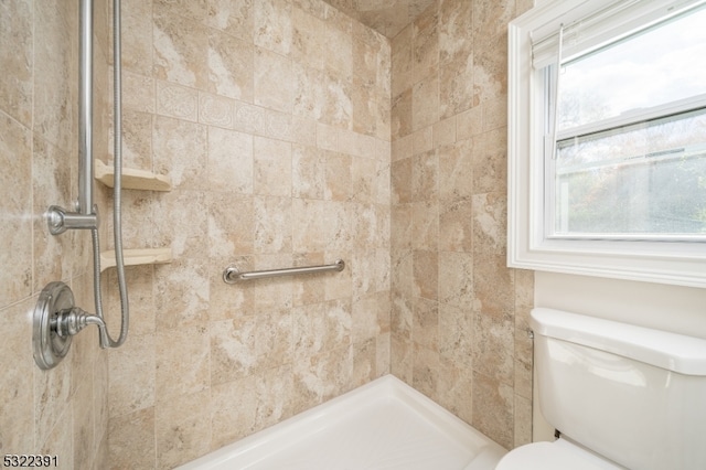 bathroom with tiled shower and toilet