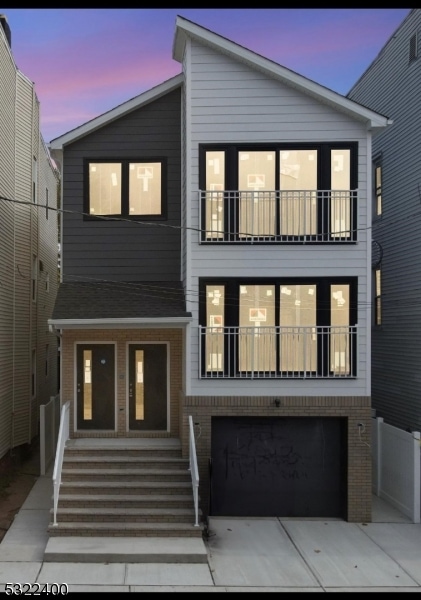 view of front of home with a balcony and a garage