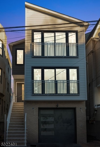 back of property with a garage and a balcony