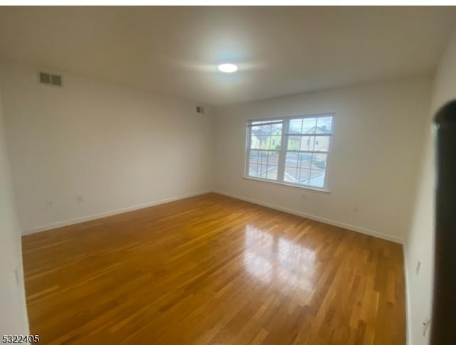 unfurnished room with hardwood / wood-style floors