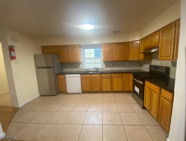 kitchen with decorative backsplash, black gas range oven, sink, dishwasher, and stainless steel refrigerator