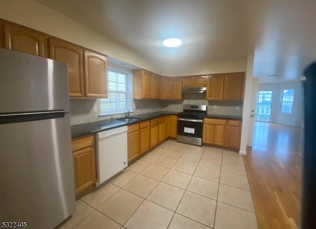 kitchen with light tile patterned floors, sink, appliances with stainless steel finishes, and tasteful backsplash