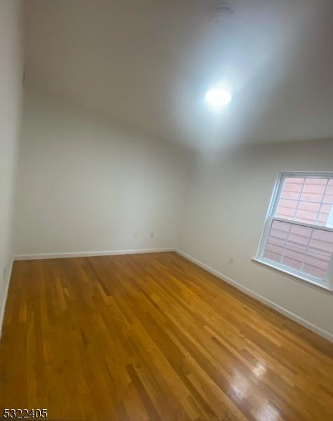 unfurnished room with hardwood / wood-style flooring