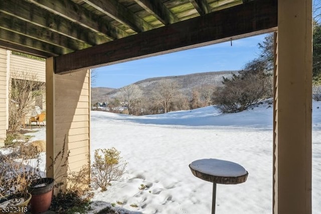 snow covered patio with a mountain view