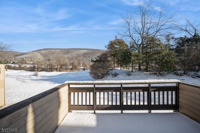 snow covered deck with a mountain view