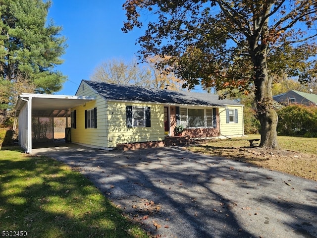 ranch-style house featuring a front yard and a carport