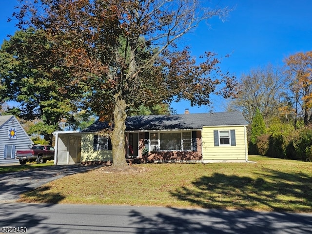 ranch-style home featuring a carport and a front lawn