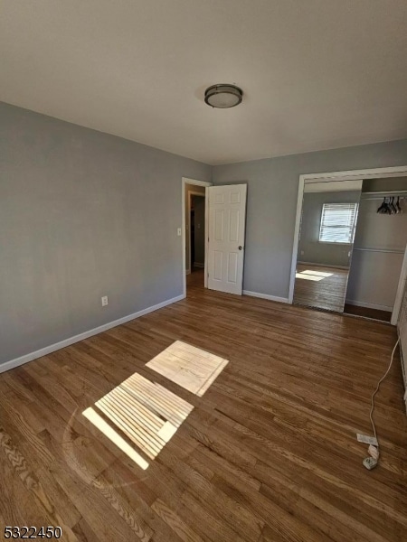 unfurnished bedroom with a closet and dark hardwood / wood-style floors