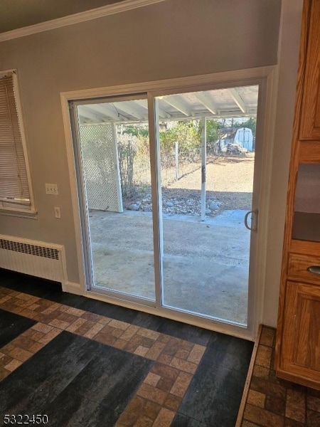 doorway to outside featuring crown molding and radiator heating unit