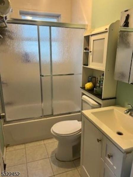 full bathroom featuring shower / bath combination with glass door, vanity, toilet, and tile patterned flooring