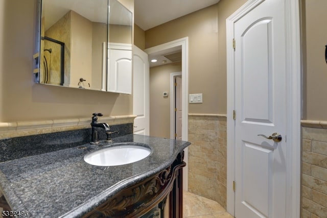 bathroom with vanity and tile walls