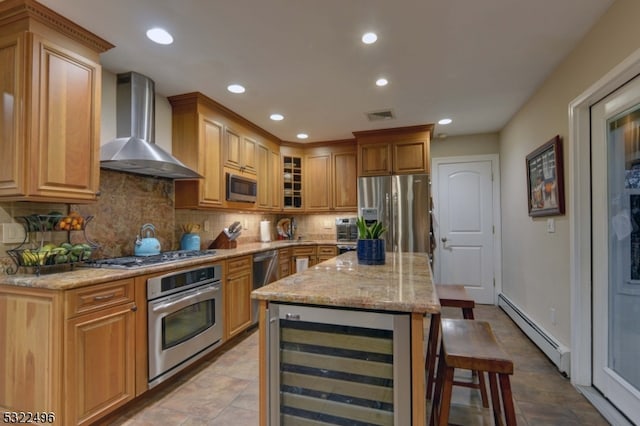 kitchen with wall chimney range hood, a breakfast bar area, a baseboard heating unit, wine cooler, and appliances with stainless steel finishes