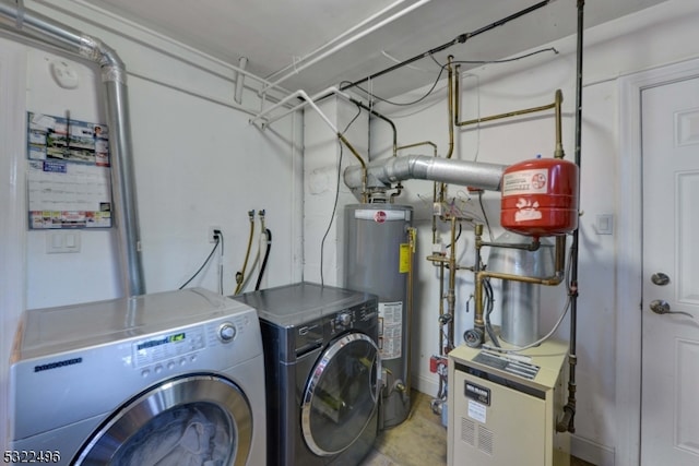 clothes washing area with washer and dryer and water heater