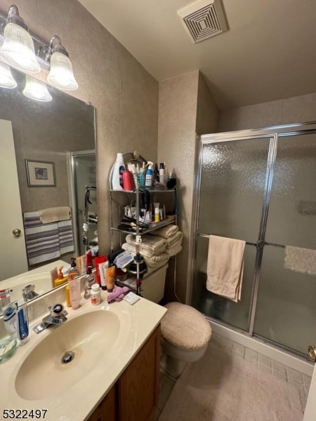 bathroom with toilet, an enclosed shower, vanity, and tile patterned flooring