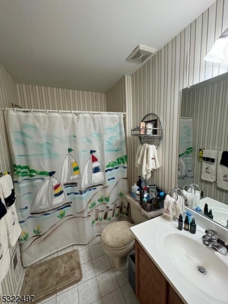 bathroom with tile patterned flooring, curtained shower, vanity, and toilet