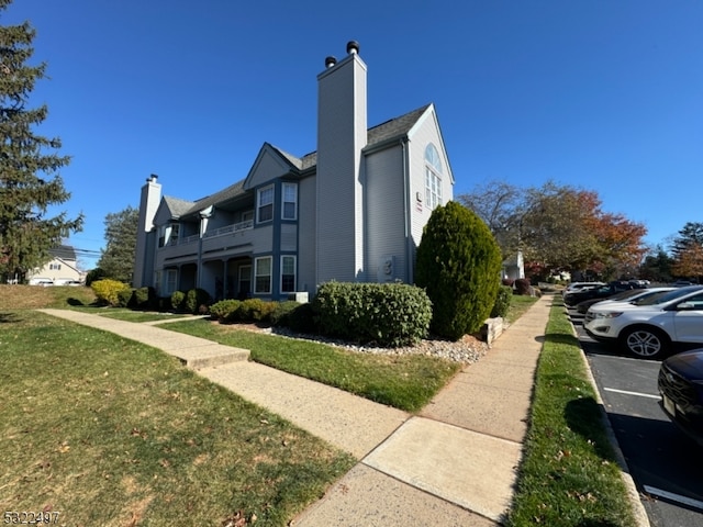 view of property exterior with a lawn and a balcony