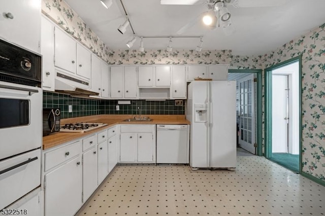 kitchen featuring light floors, white cabinets, white appliances, under cabinet range hood, and wallpapered walls