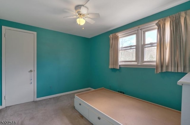 interior space featuring carpet, baseboards, and a ceiling fan