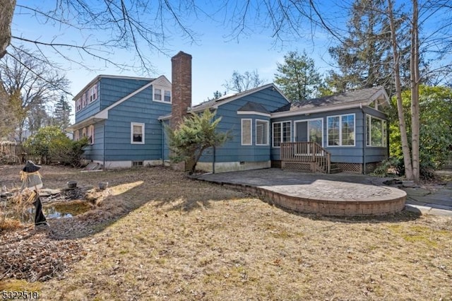 rear view of property featuring a patio area, a chimney, and a sunroom