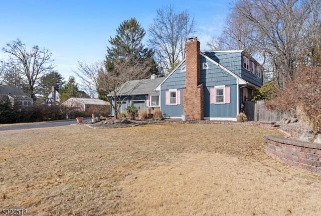 view of front of property featuring a front lawn and a chimney