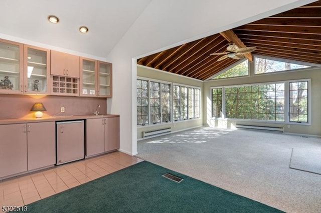 interior space with baseboard heating, light tile patterned flooring, visible vents, and light colored carpet