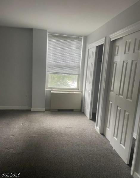 unfurnished bedroom with carpet, multiple closets, and baseboards