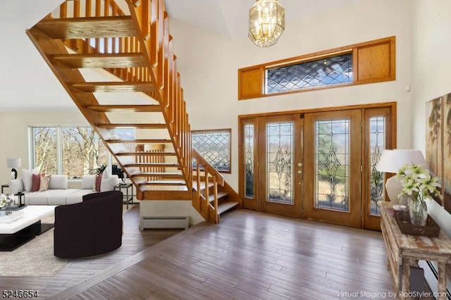 entryway with french doors, a notable chandelier, baseboard heating, and dark hardwood / wood-style floors