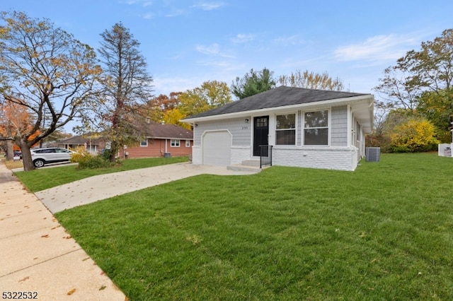 view of front of home featuring central AC, a garage, and a front lawn