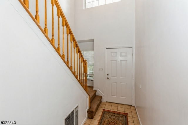 foyer with light tile patterned floors and a high ceiling